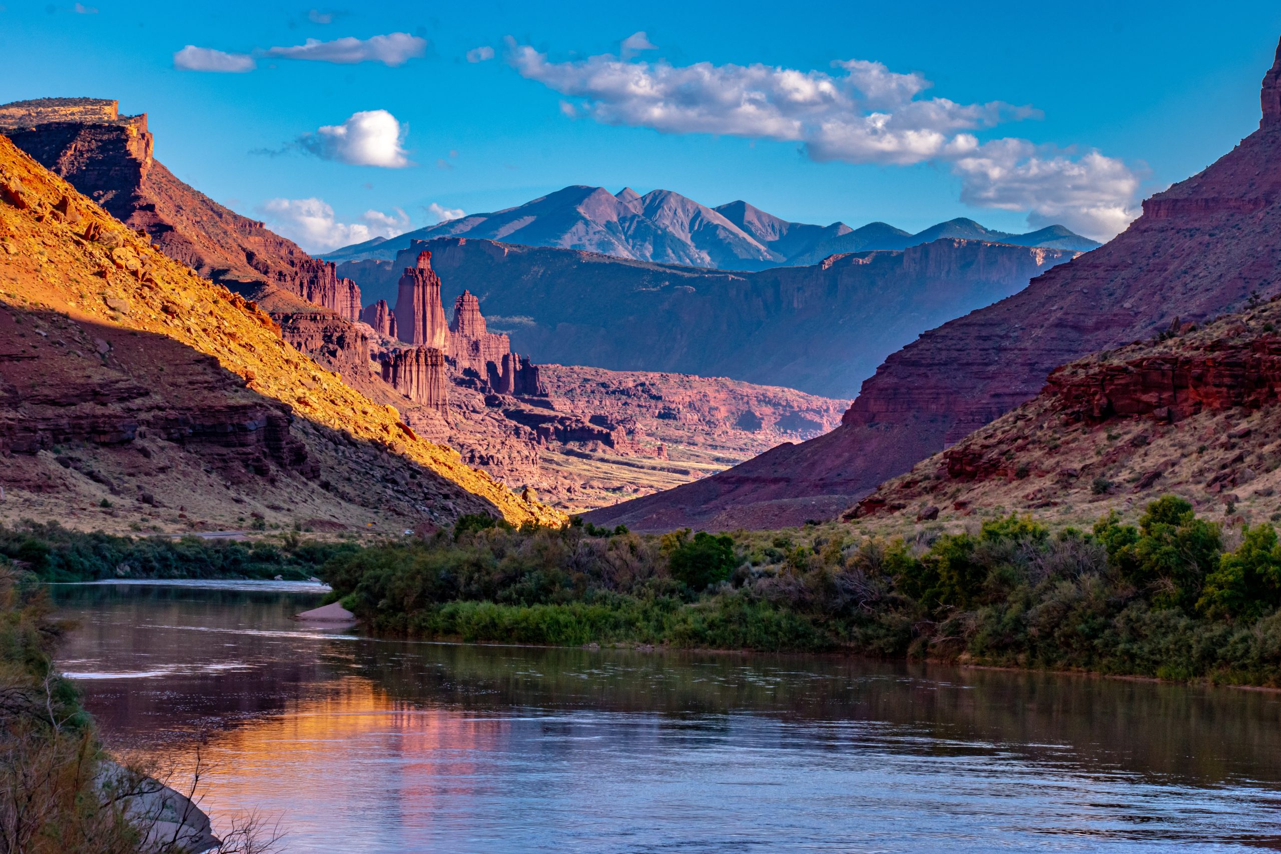The red sandstone spires of Fisher Towers rising above the desert near Moab, Utah, with the La Sal Mountains in the distance